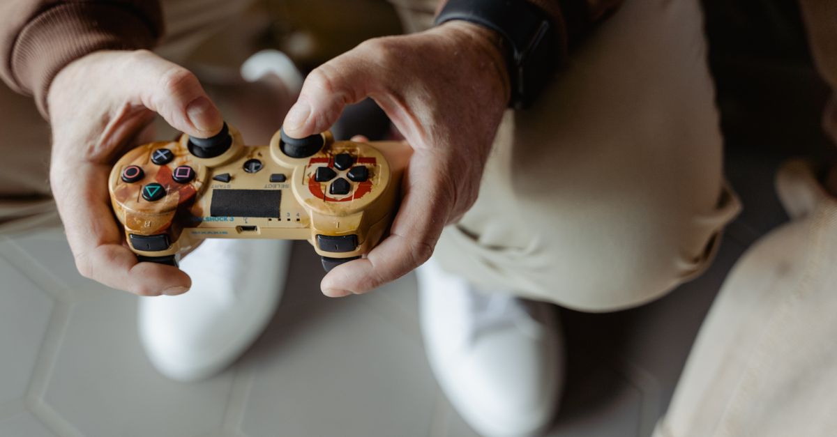 A person playing video games with a vintage-style controller indoors.